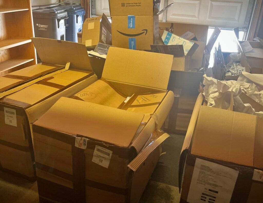Cluttered garage with stacked and open Amazon boxes, crumpled paper, and other items—perfect for junk removal services in Southern California.