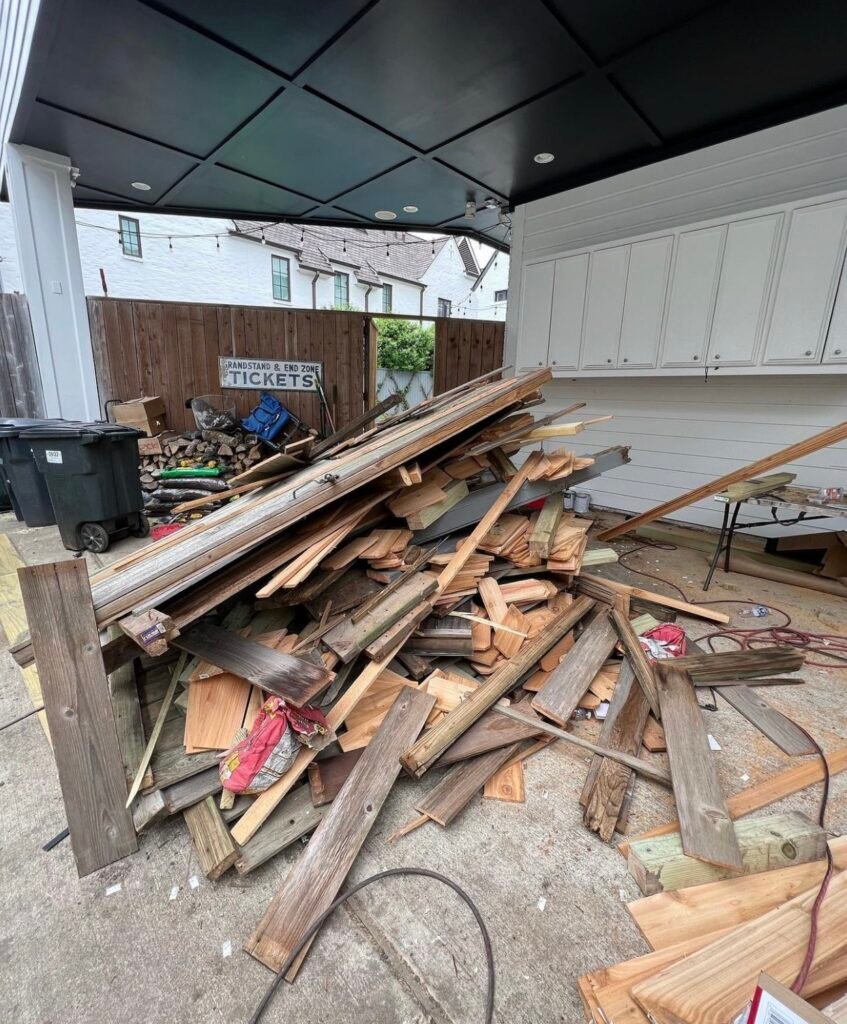 A large pile of discarded wood and debris is stacked haphazardly on the ground.